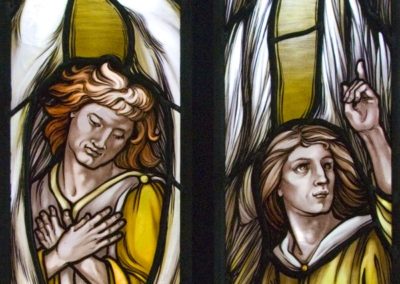 The Angel on the left signifies a prayerful position using hands, while the other points to the church sactuary and to the heavens.